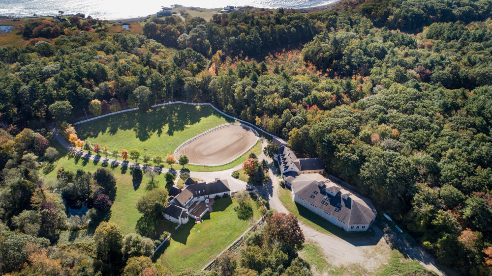 Aerial view of Rand Stables — barns, riding ring, and the Maine coast in York, Maine