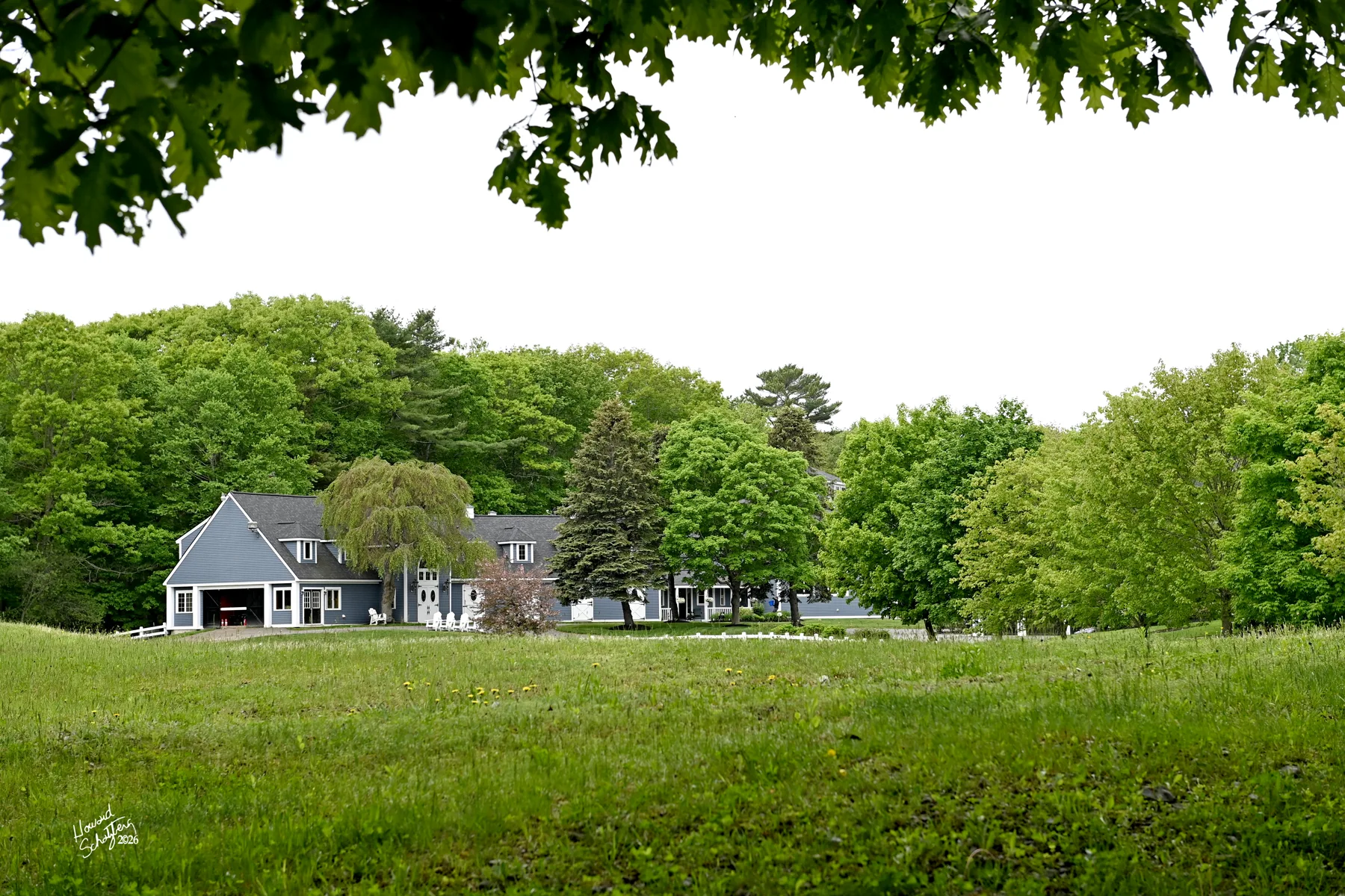 Rand Stables buildings framed by open pasture and white fencing